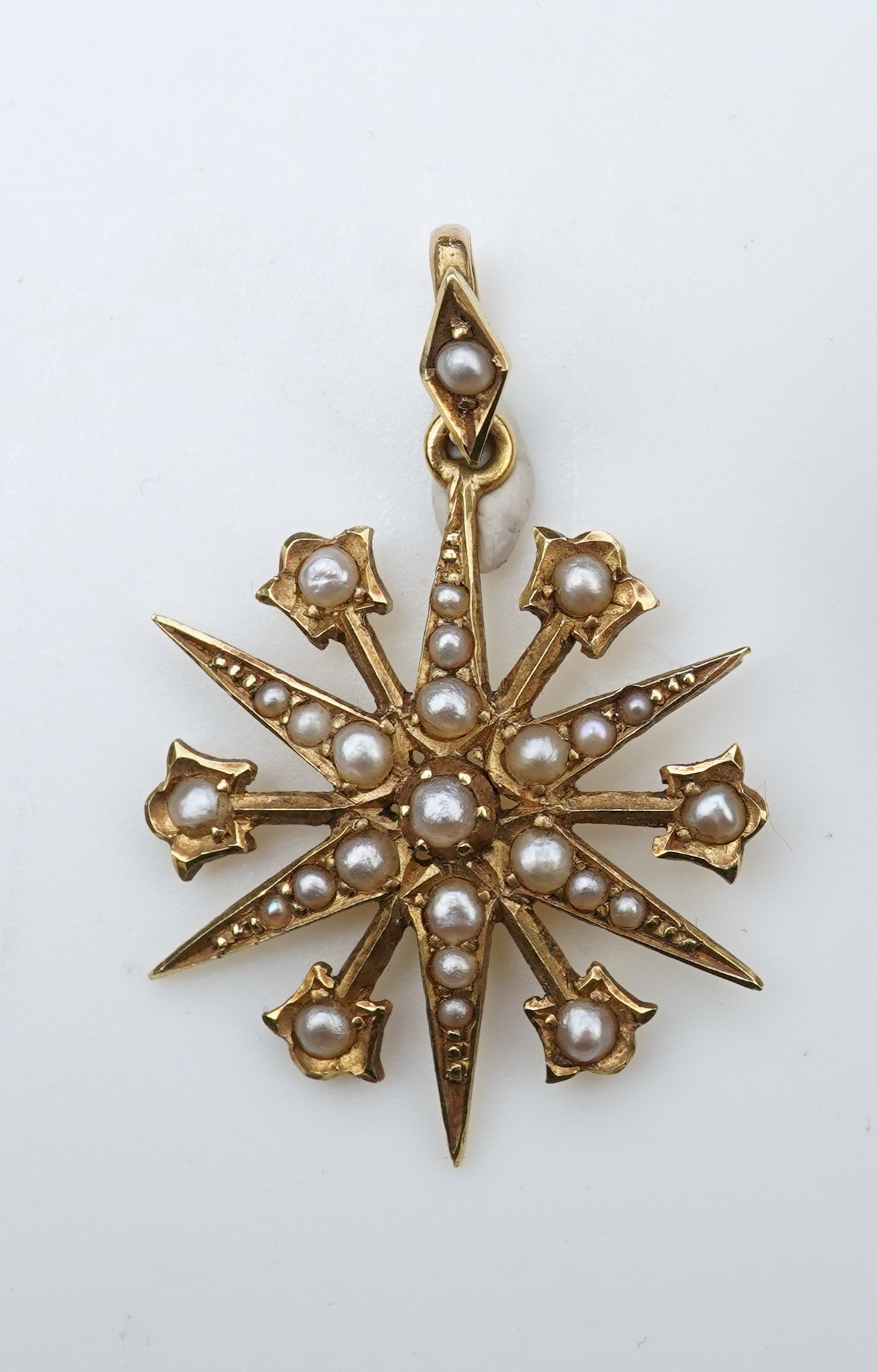 A gem-set egg pendant and an Edwardian seed pearl pendant